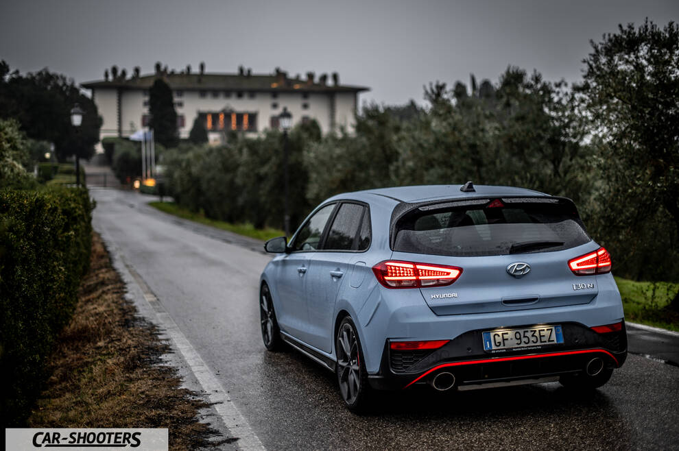 Hyundai i30N – rear three-quarter, light blue on a wet country road
