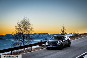 Tesla Model Y – front three-quarter, black against a mountain backdrop
