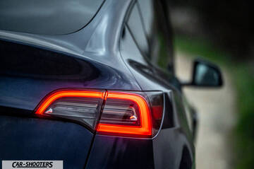 Tesla Model Y – rear three-quarter, dark blue against a blurred background