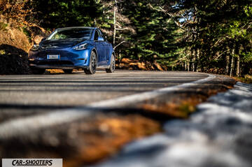 Tesla Model Y – front three-quarter, blue on a country road