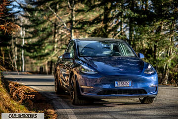 Tesla Model Y – front three-quarter, blue on a country road