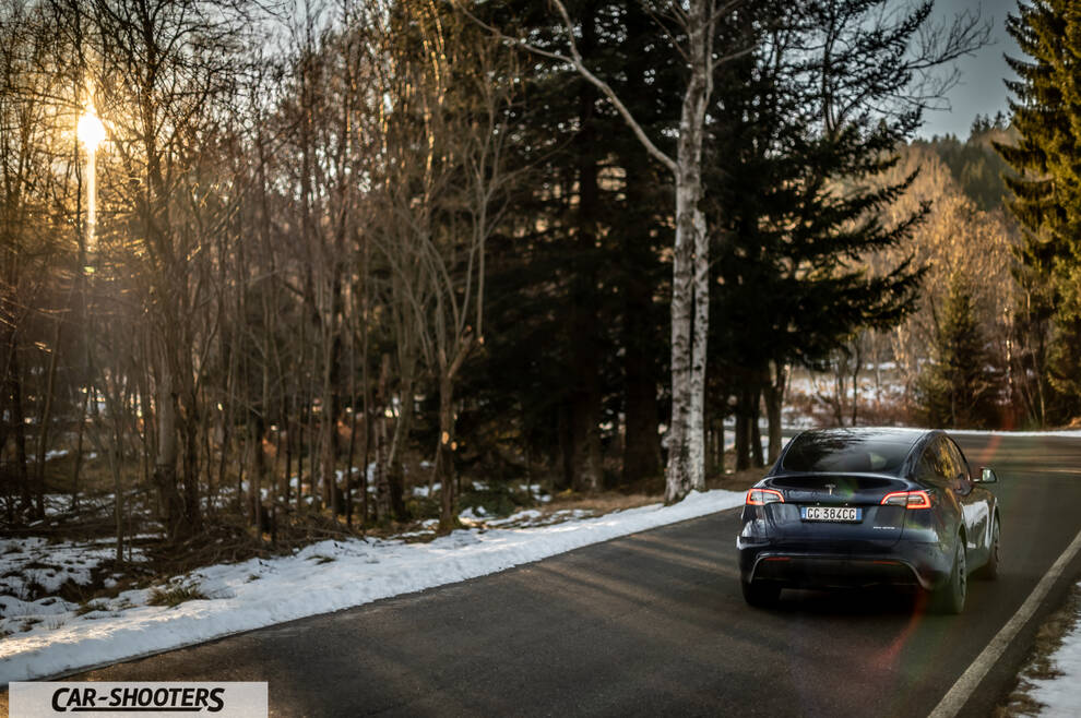Tesla Model Y – rear three-quarter, dark blue on a snowy country road