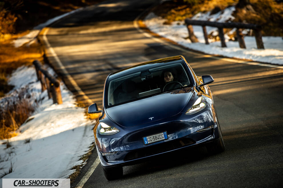 Tesla Model Y – front three-quarter, dark blue on a winding road