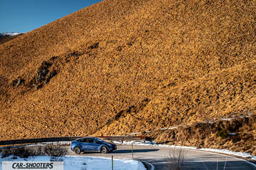 Tesla Model Y – side profile, blue against a mountain backdrop