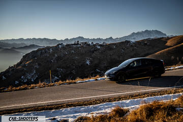 Tesla Model Y – front three-quarter, dark grey on a mountain road