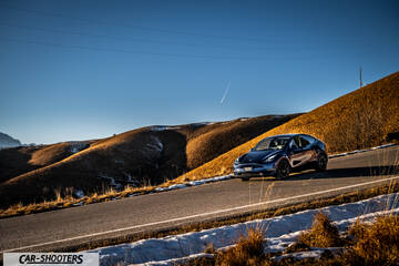 Tesla Model Y – front three-quarter, dark blue on a winding mountain road