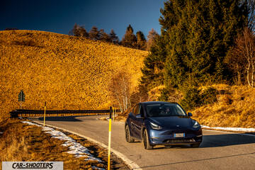 Tesla Model Y – front three-quarter, blue on a mountain road