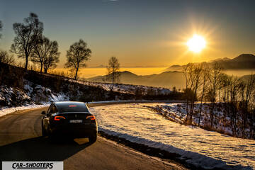 Tesla Model Y – rear view, black against a mountain backdrop at sunset
