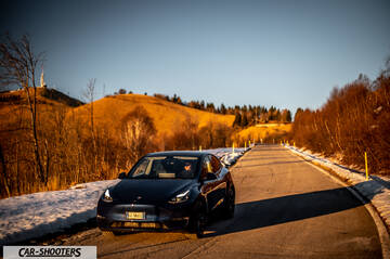 Tesla Model Y – front three-quarter, dark blue on a snowy country road