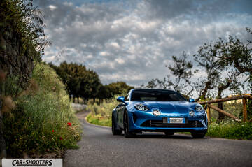 Alpine A110 – front three-quarter, blue on a country road