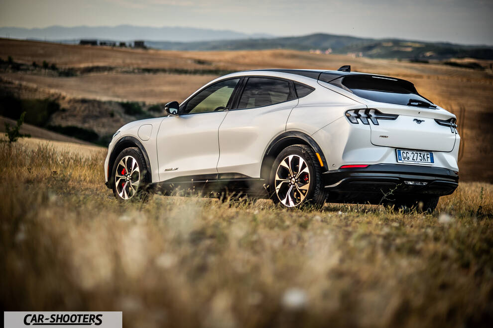 Ford Mustang Mach E – rear three-quarter, white against a mountain backdrop
