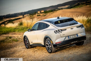 Ford Mustang Mach E – rear three-quarter, white on a dirt road with hills