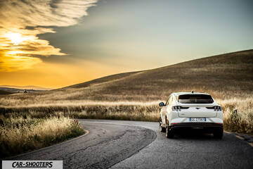 Ford Mustang Mach E – rear three-quarter, white on a winding country road
