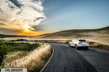 Ford Mustang Mach E – rear three-quarter, white on a winding road