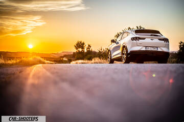 Ford Mustang Mach E – rear three-quarter, white on a country road at sunset
