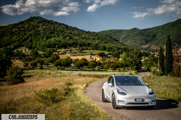 Tesla Model Y Performance – front three-quarter, white against a mountain backdrop