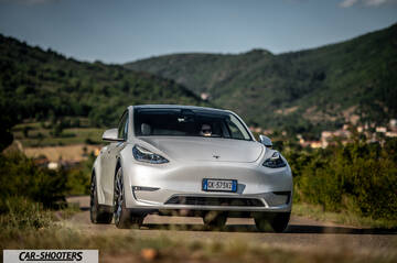 Tesla Model Y Performance – front three-quarter, silver against a mountain backdrop