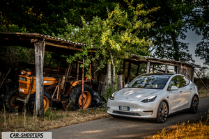 Tesla Model Y Performance – front three-quarter, white on a rural road next to an old tractor