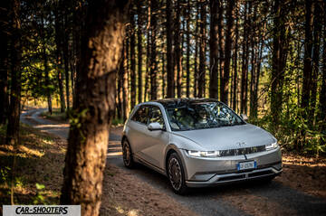 Hyundai Ioniq 5 – front three-quarter, silver on a forest road