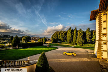 Porsche 911 Turbo Cabrio – side profile, yellow in front of a historic building