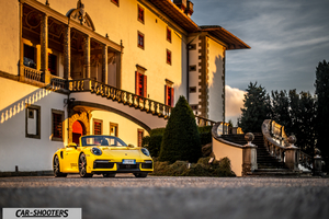 Porsche 911 Turbo Cabrio – front three-quarter, yellow against a historic building backdrop