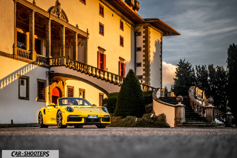 Porsche 911 Turbo Cabrio – front three-quarter, yellow against a historic building backdrop