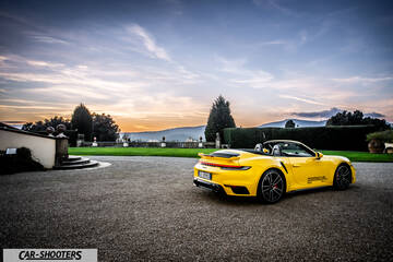 Porsche 911 Turbo Cabrio – rear three-quarter, yellow against a mountain backdrop