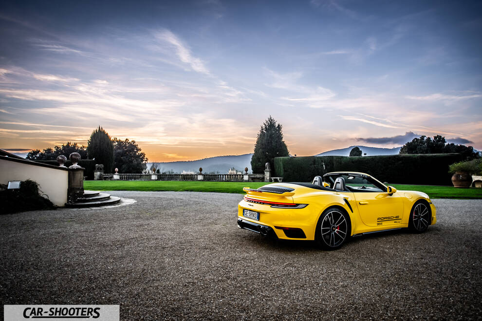 Porsche 911 Turbo Cabrio – rear three-quarter, yellow against a mountain backdrop
