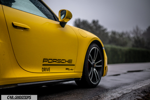 Porsche 911 Turbo Cabrio – side profile, yellow on a wet road