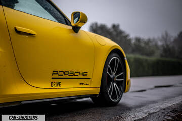 Porsche 911 Turbo Cabrio – side profile, yellow on a wet road