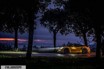 Porsche 911 Turbo Cabrio – side profile, yellow on a country road at dusk