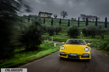 Porsche 911 Turbo Cabrio – front three-quarter, yellow on a country road