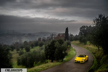 Porsche 911 Turbo Cabrio – front three-quarter, yellow on a country road