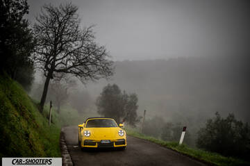 Porsche 911 Turbo Cabrio – front three-quarter, yellow on a country road