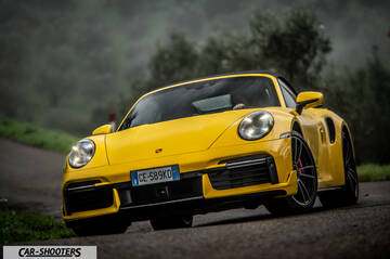 Porsche 911 Turbo Cabrio – front three-quarter, yellow on a winding country road