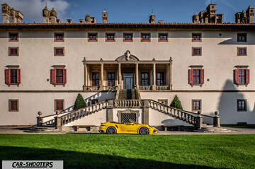 Porsche 911 Turbo Cabrio – side profile, yellow in front of a historic building