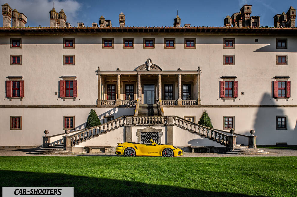 Porsche 911 Turbo Cabrio – side profile, yellow in front of a historic building