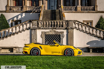 Porsche 911 Turbo Cabrio – side profile, yellow against a historic building
