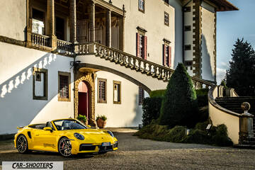 Porsche 911 Turbo Cabrio – front three-quarter, yellow in front of a historic villa