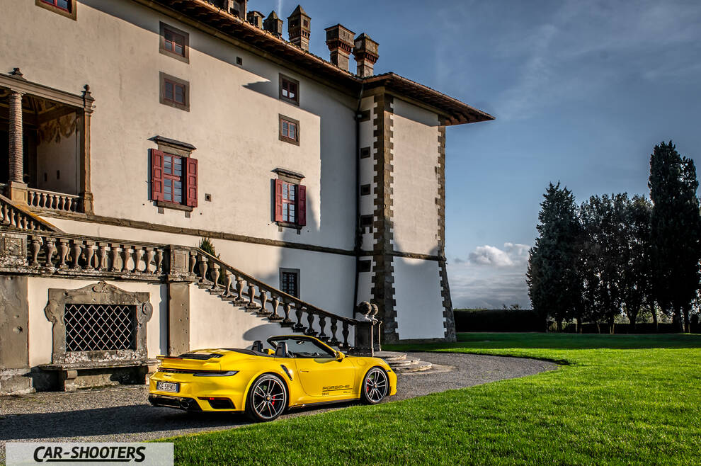 Porsche 911 Turbo Cabrio – rear three-quarter, yellow against a historic building