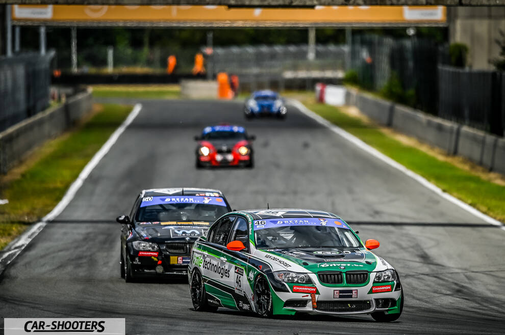 front three-quarter, white with green and black livery racing on a track