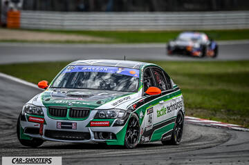 front three-quarter, white with green and black on a race track