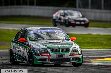 front three-quarter, white with green and black graphics on a racing track
