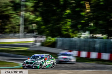 front three-quarter, white with green and black graphics on a race track