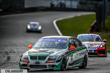 front three-quarter, silver and green on a race track