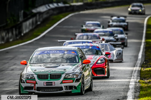 front three-quarter, white with green racing on a track