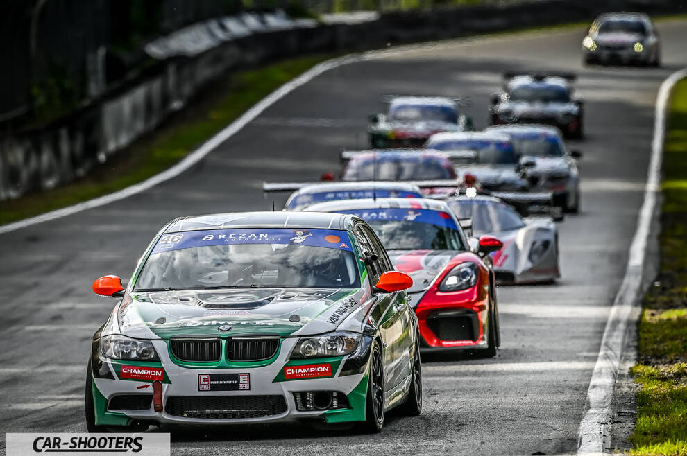 front three-quarter, white with green racing on a track