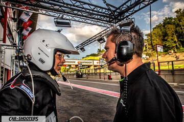 detail, driver and crew member talking in pit lane