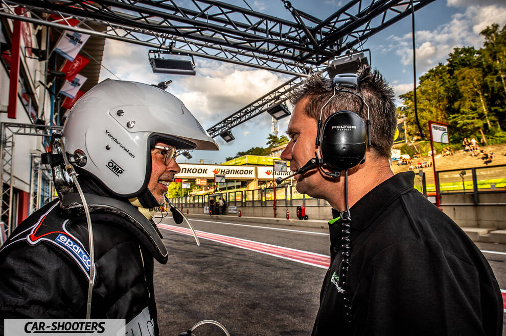 detail, driver and crew member talking in pit lane