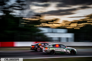 rear three-quarter, white on a race track at dusk